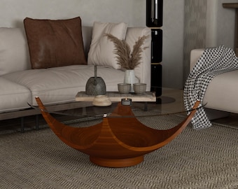 May include: A modern living room features a low, wooden coffee table with a unique, curved design. The table has a clear glass top. The room includes a beige sofa, decorative pillows, and a patterned rug.
