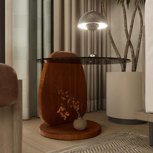 Puede incluir: Una mesa auxiliar moderna de madera con una tapa de cristal oscuro. La mesa tiene una forma orgánica única con un acabado cálido de color marrón rojizo. Un pequeño jarrón con flores secas se encuentra en el estante inferior. Una lámpara plateada está encima de la mesa.