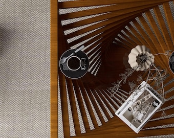 May include: A wooden coffee table with a unique spiral design. The table has a dark brown finish and features a decorative plate with a spoon and fork, a white vase, and a magazine. The table is placed on a light gray patterned rug.