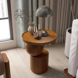 A handmade solid wood side table designed for modern and minimalist interiors. The natural wood surface shows subtle variations that highlight its unique character. Perfect for placing decor items, lighting, or everyday essentials. Ideal for living rooms, bedrooms, or office spaces, offering both functionality and a warm, refined aesthetic.