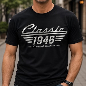 Op de afbeelding: Zwart T-shirt met zilverkleurige tekst "Classic 1946 - Limited Edition". Het ontwerp toont het woord "Classic" in een gestileerd lettertype boven het nummer "1946" met horizontale lijnen. De tekst "Limited Edition" staat eronder.