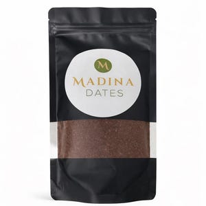 May include: A black pouch with a white oval label featuring the text "MADINA DATES" in gold. The pouch contains a brown granular substance, and a white stripe is visible near the centre.