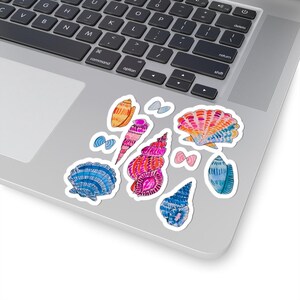 May include: A collection of colorful seashell stickers in various shapes and sizes. The stickers feature watercolor designs in shades of blue, pink, orange, and yellow. Some stickers have a textured appearance, while others are smooth. The stickers are placed on a laptop.