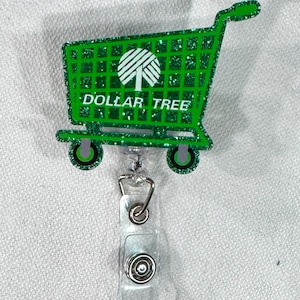 May include: A green glittery shopping cart badge reel with the text "DOLLAR TREE" and a tree logo. The badge reel has a clear plastic strap and a metal clip.