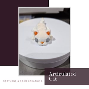 Pode incluir: Uma figura de gato articulado branco com detalhes de orelhas laranja, olhos cinzentos e nariz laranja. O gato está deitado sobre uma superfície branca. O texto "Articulated Cat" é visível na imagem.