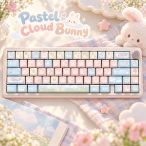 May include: A mechanical keyboard with a light pink frame and pastel-colored keycaps in shades of blue, pink, and white. The keys feature various small icons and the text Pastel Cloud Bunny is displayed above the keyboard in a rounded font.