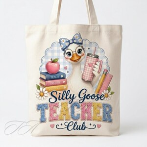 Peut inclure: Un sac fourre-tout en toile couleur crème orné d'une oie portant un nœud bleu à motifs de marguerites et des lunettes. L'oie tient un gobelet rose à carreaux près d'une pile de livres marqués Teach, Inspire, Encourage, un crayon et une règle.