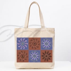 May include: A beige canvas tote bag featuring a rectangular graphic print composed of six square panels. The panels alternate between purple and brown backgrounds, each decorated with intricate, symmetrical floral and leaf-like mandala patterns.