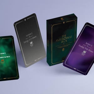 以下が含まれることがあります： 「The Antidormat Deck」の画像で、3つのカードデッキと1つのボックスがあります。デッキは緑、グレー、紫のグラデーションカラーです。デッキのテキストには、「Section 1 Boundaries & Bite」、「Section 3 Energy & Evolution」、および「Section 2 Healing With Humor」が含まれています。