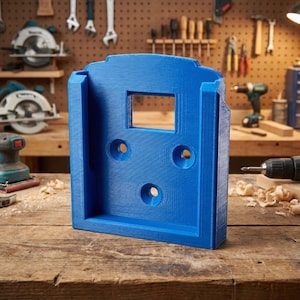 May include: A bright blue, 3D-printed tool holder with a rectangular opening and three circular holes. The holder is designed to mount on a wall or other surface. The background shows woodworking tools.
