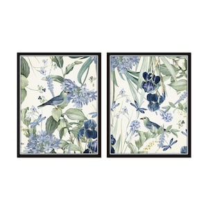 May include: Two framed prints with a botanical theme. The prints feature blue and green flowers, leaves, and birds on a white background.