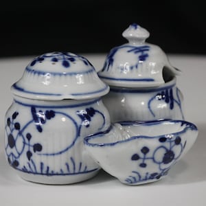 Könnte beinhalten: Ein Set aus drei weißen Porzellan-Servierschalen mit blauen Blumenmustern. Das Set besteht aus zwei Töpfen mit Deckel und einer kleinen, offenen Schale. Das Blau-Weiß-Farbschema verleiht dem Set ein klassisches, elegantes Aussehen.