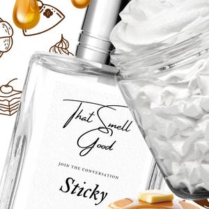May include: A clear perfume bottle with a silver cap, labeled "That Smell Good Sticky Eau de Parfum." The image includes a stack of pancakes with syrup, whipped cream, and caramel syrup, suggesting a sweet fragrance.