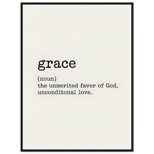 May include: A framed print with the word "grace" in a bold, black font. Below, the definition is provided: "(noun) the unmerited favor of God, unconditional love." The background is a cream color, and the frame is black.