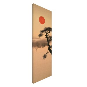 May include: A vertical rectangular canvas print featuring a beige background with a dark silhouette of a pine tree on the right side. A solid red circle representing the sun is positioned in the upper center, with soft gray clouds below the tree.