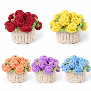 以下が含まれることがあります： 小さなベージュ色のバスケットに入った、かぎ針編みのフラワーアレンジメントが5つ。花は赤、黄、オレンジ、紫、青で、緑の葉が付いています。バスケットは織り込まれたような質感で、花は密集しています。