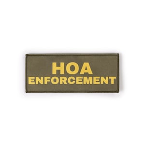 May include: Olive green rectangular patch with the words "HOA ENFORCEMENT" in bold yellow letters. The patch has a black border and is set against a white background. The text is centered on the patch.