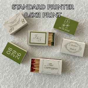 Puede incluir: Seis cajas de cerillas rectangulares con diseños personalizados. Una caja blanca presenta el texto 'JUST MARRIED' y corazones. Una caja verde muestra copas de champán y '08.29.2026'. Una caja muestra 'J&S' con cerillas verdes. Una caja blanca dice 'Z Perfect Match'. Una caja verde muestra '08 29 26'. Una caja blanca dice 'The Zarragas' con cerillas de punta roja.