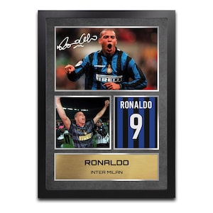 Puede incluir: Collage enmarcado con imágenes de Ronaldo con la camiseta del Inter de Milán. Incluye una foto firmada, fotos de acción y un gráfico de la camiseta con el número 9. La parte inferior tiene una placa dorada con el nombre "RONALDO" e "INTER MILAN".