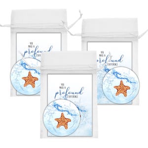 May include: Three white drawstring bags each containing a card with the text "You make a profound difference" and a round coaster. The coasters feature a starfish design with blue water splashes.