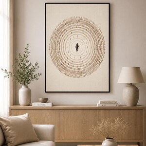 Könnte beinhalten: Gerahmter Kunstdruck mit einer zentralen Figur, die von konzentrischen Kreisen kleinerer Figuren in Brauntönen umgeben ist. Das Kunstwerk hat einen minimalistischen Stil und ist vor einem neutralen Hintergrund platziert, was eine beruhigende Ästhetik erzeugt. Der Rahmen ist schwarz.
