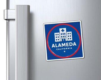 May include: A square magnet with a blue background and a red circular border. The magnet features a white illustration of a building with a cross on top, and the text "ALAMEDA CALIFORNIA" in white.