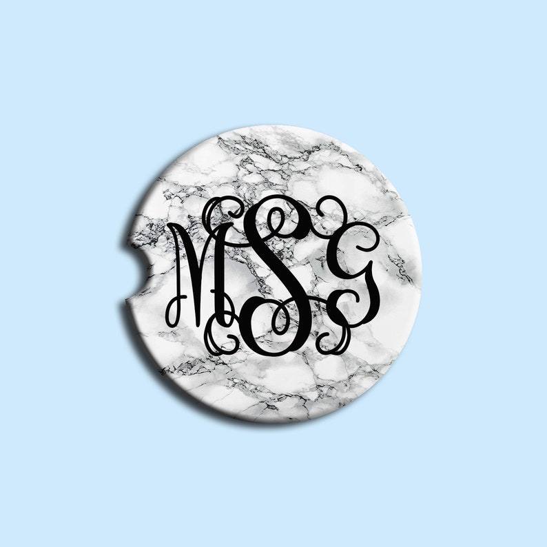 May include: White marble coaster with a black monogram of the letters "MSC" in a script font.