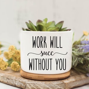 May include: White ceramic planter with a succulent plant inside. The planter has black text that reads "Work will succ without you".