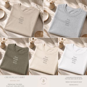 Peut inclure: Une collection de cinq t-shirts à col rond pliés en beige, gris clair, vert olive, crème et blanc. Chaque t-shirt présente le texte centré "Your design, your story" dans une police gris foncé. Les t-shirts sont disposés à plat.