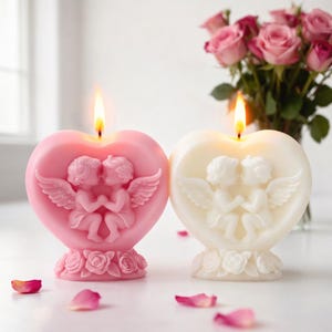 Può includere: Due candele a forma di cuore, una rosa e una bianca, ciascuna con una fiamma che brucia. Le candele presentano un rilievo di due cherubini e sono poste su una base di rose. Un bouquet di rose rosa è sullo sfondo.