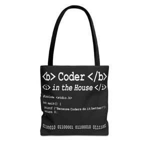 Op de afbeelding: Zwarte draagtas met witte tekst "Coder in the House", vergezeld van codefragmenten en binaire getallen. De tas heeft zwarte handvatten. Een leuke tas voor programmeurs.
