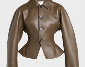 May include: A brown leather jacket with a tailored fit. The jacket features a classic collar, three dark buttons, and a unique waist design. The sleeves are long, and the jacket appears to be made of high-quality leather. The overall style is modern and chic.