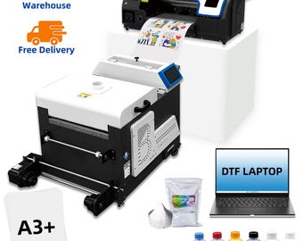 May include: A large black and white DTF printer with a roll of printed paper. The image also shows a laptop with the text "DTF LAPTOP", ink bottles, and A3+ paper.