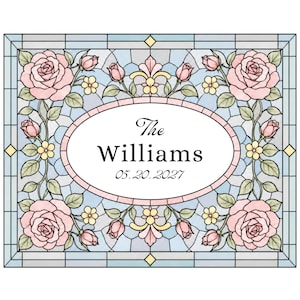 Può includere: Un pannello rettangolare in vetro colorato con un ovale centrale contenente il testo The Williams e 05.20.2027. Il design include rose rosa, foglie verdi e piccoli fiori gialli su uno sfondo a griglia geometrica azzurro.