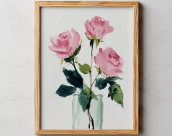 May include: A framed art print featuring a watercolor painting of three pink roses in a glass vase. The roses have green stems and leaves. The frame is made of light-colored wood. The text "PIXEL TO PRINT" is at the top.