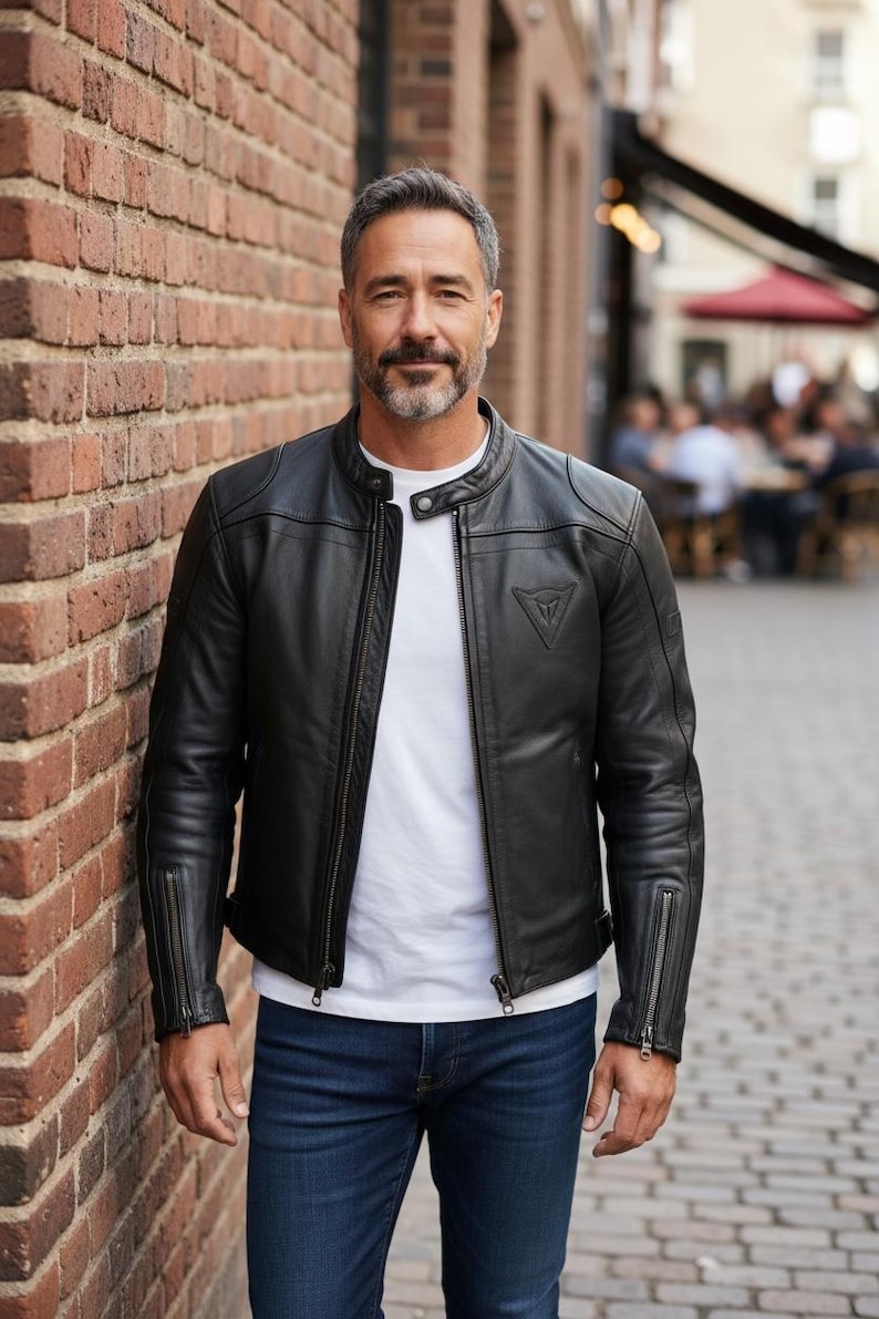 May include: A set of three ceramic mugs with a speckled, cream-colored glaze. Each mug features a different hand-painted design: a blue and green leaf, a yellow and orange flower, and a red and pink berry. The mugs have a simple, rounded shape.