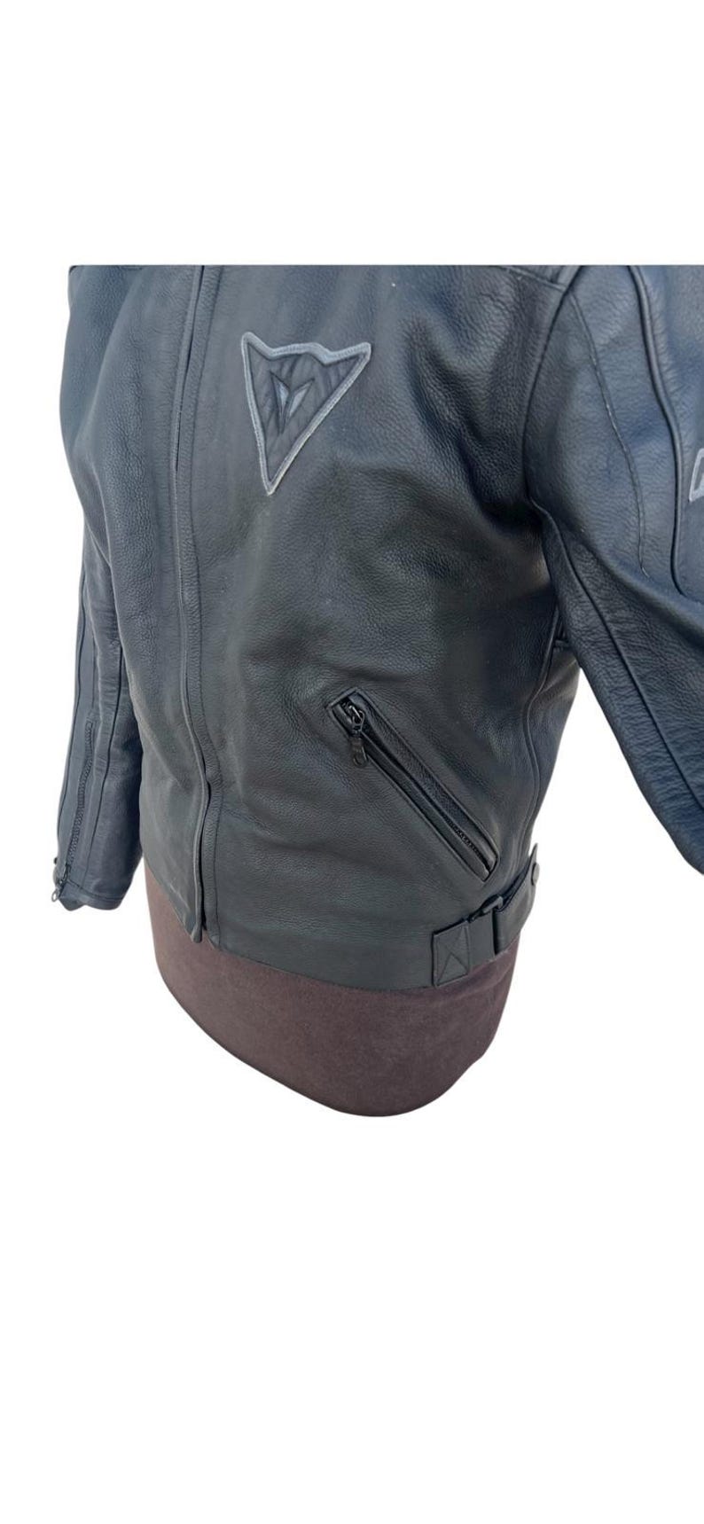 May include: A set of three ceramic mugs with a speckled, matte finish. The mugs are in shades of cream, light gray, and dark gray. Each mug has a simple, minimalist design and a rounded handle. The mugs are likely for coffee or tea.