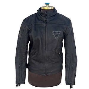 May include: A white ceramic mug with a black handle and the text "But First, Coffee" in a handwritten style. The mug is on a white surface. The mug is approximately 4 inches tall.