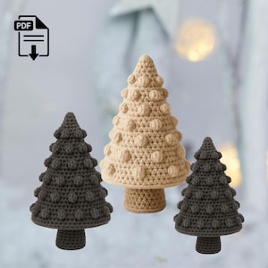 Op de afbeelding: Drie handgemaakte gehaakte kerstbomen in verschillende bruin- en beigetinten. De bomen hebben een textuur met bobbelsteek en worden gepresenteerd tegen een neutrale achtergrond. Het PDF-pictogram staat linksboven.