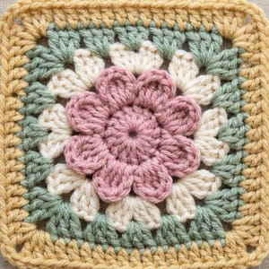 May include: A square, handmade crochet piece featuring a floral design. The center of the square is a flower in shades of pink, surrounded by white, green, and a yellow border. The piece is likely a coaster or part of a larger craft project.