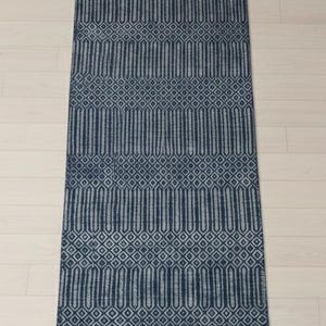 Puede incluir: Una alfombra rectangular tipo pasillero con un patr&oacute;n geom&eacute;trico en azul marino oscuro y gris claro. El dise&ntilde;o consiste en bandas horizontales alternas de formas de diamante repetidas y columnas hexagonales verticales alargadas.