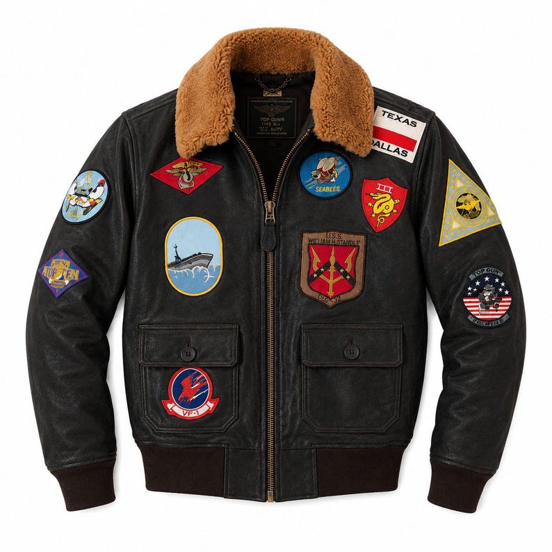 Peut inclure: Un blouson aviateur en cuir marron fonc&eacute; avec un col en fausse fourrure beige, une fermeture &eacute;clair frontale et des poignets c&ocirc;tel&eacute;s. Le blouson est orn&eacute; de nombreux &eacute;cussons brod&eacute;s color&eacute;s de style militaire, dont un &eacute;cusson Texas Dallas.