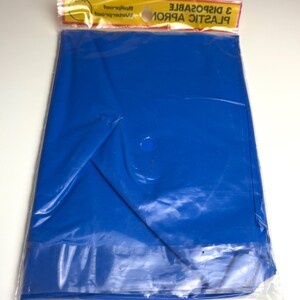 May include: A package containing a folded, bright blue plastic sheet. The sheet is sealed in a clear plastic bag with a yellow and red header that reads "3 DISPOSABLE PLASTIC APRONS".