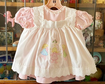 vintage pink baby dress with white pinafore, 12 months, Nursery Rhyme, 3 girls playing appliquéd on pinafore, lace detailing
