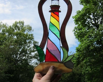 Stained glass Rainbow Island Lighthouse, suncatcher, window hanging. Deep purple border glass. 13.5 inches high by 7 wide.