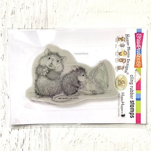 Op de afbeelding: Een transparante plastic verpakking met een klevend rubberen stempel met twee muizen, waarvan er één een groot blad vasthoudt. De stempel is geëtiketteerd met "Friend & Buddy" en maakt deel uit van de "House Mouse Designs" collectie van "Happy Hoppers".