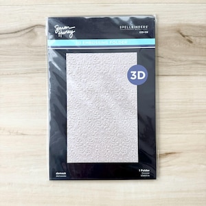 May include: A Simon Hurley 3D embossing folder with a damask design. The black package has white text and a 3D graphic. Ideal for paper crafts and scrapbooking. The folder measures 14 x 21.6 cm.
