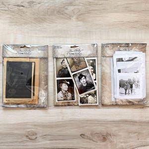 May include: Three packages of vintage-style ephemera. The packages contain old photographs and paper ephemera. The packaging has a distressed, vintage aesthetic. The packages are on a light wood-grain surface.