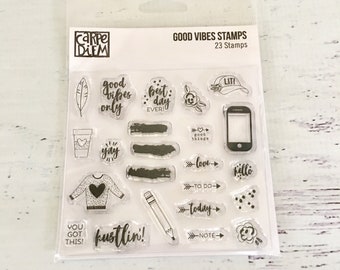 Op de afbeelding: Een transparante plastic vel met 23 transparante stempels met verschillende zinnen en ontwerpen. Het vel is gelabeld met "Good Vibes Stamps" en "23 Stamps". Sommige van de stempels omvatten "good vibes only", "best day ever", "lit", "love", "hello", "to do", "today", "note", "you got this" en "kustlin!"