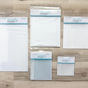 May include: Five clear plastic Insta Flip pocket sleeves in various rectangular sizes, each packaged in a sealed bag with a white header card featuring blue text and branding. The sleeves are arranged in a group on a light wood surface.